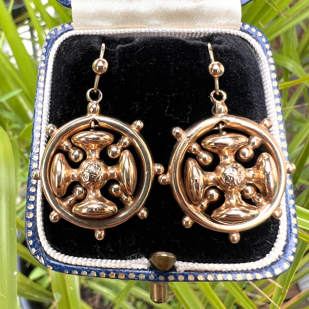 A pair of Victorian 9ct yellow gold drop earrings featuring a circular wheel design with a central square cross motif. View IX