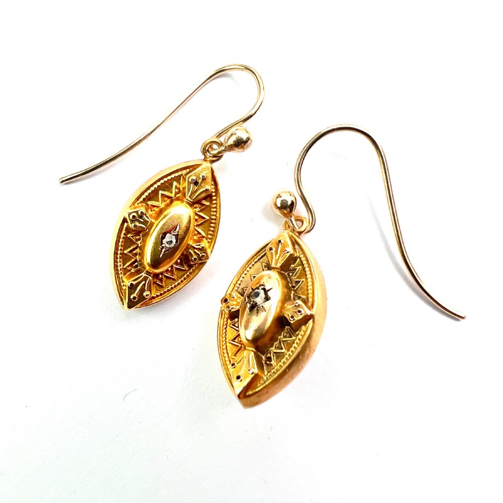 A pair of Victorian 9ct yellow gold marquise-shaped drop earrings featuring star-set diamond centres and engraved geometric detail. View VI