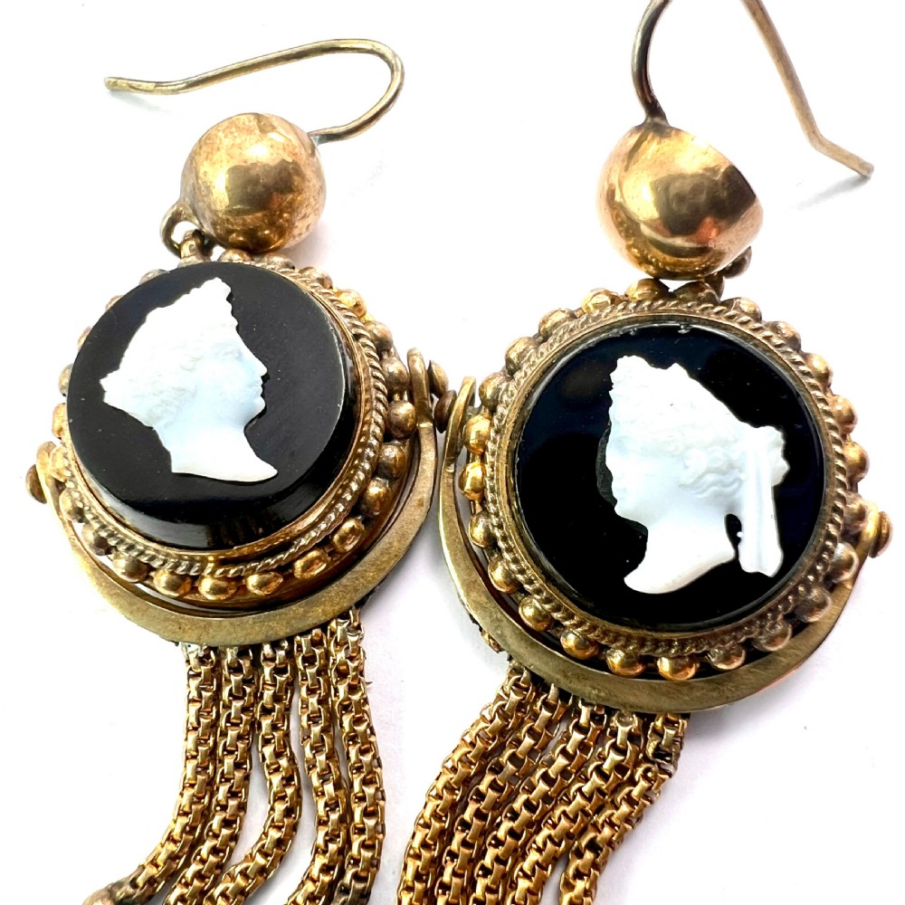 A pair of Victorian gold drop earrings featuring carved classical profile cameos mounted on black discs with cascading foxtail chain tassels. View VI