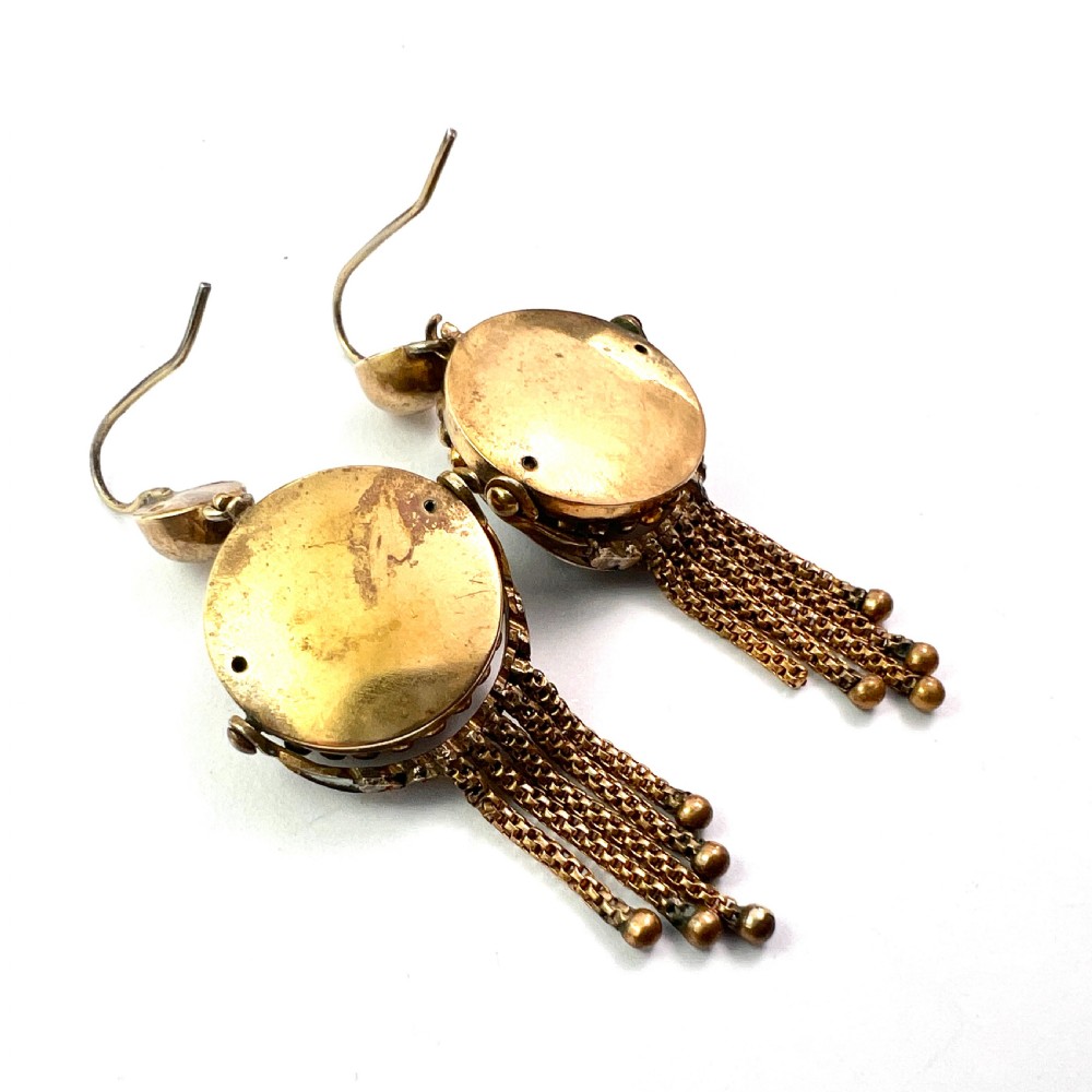 A pair of Victorian gold drop earrings featuring carved classical profile cameos mounted on black discs with cascading foxtail chain tassels. View VII