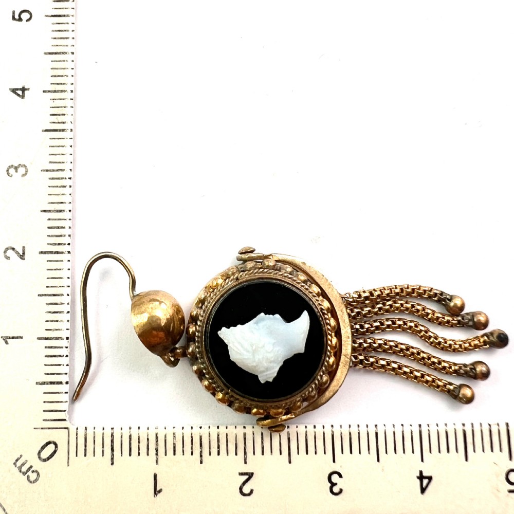 A pair of Victorian gold drop earrings featuring carved classical profile cameos mounted on black discs with cascading foxtail chain tassels. View VIII