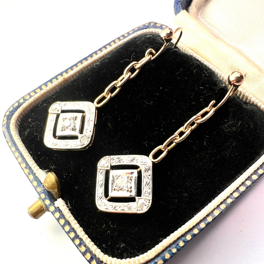 A pair of Edwardian style diamond drop earrings crafted in yellow and white gold with diamond-shaped engraved pendants. View II