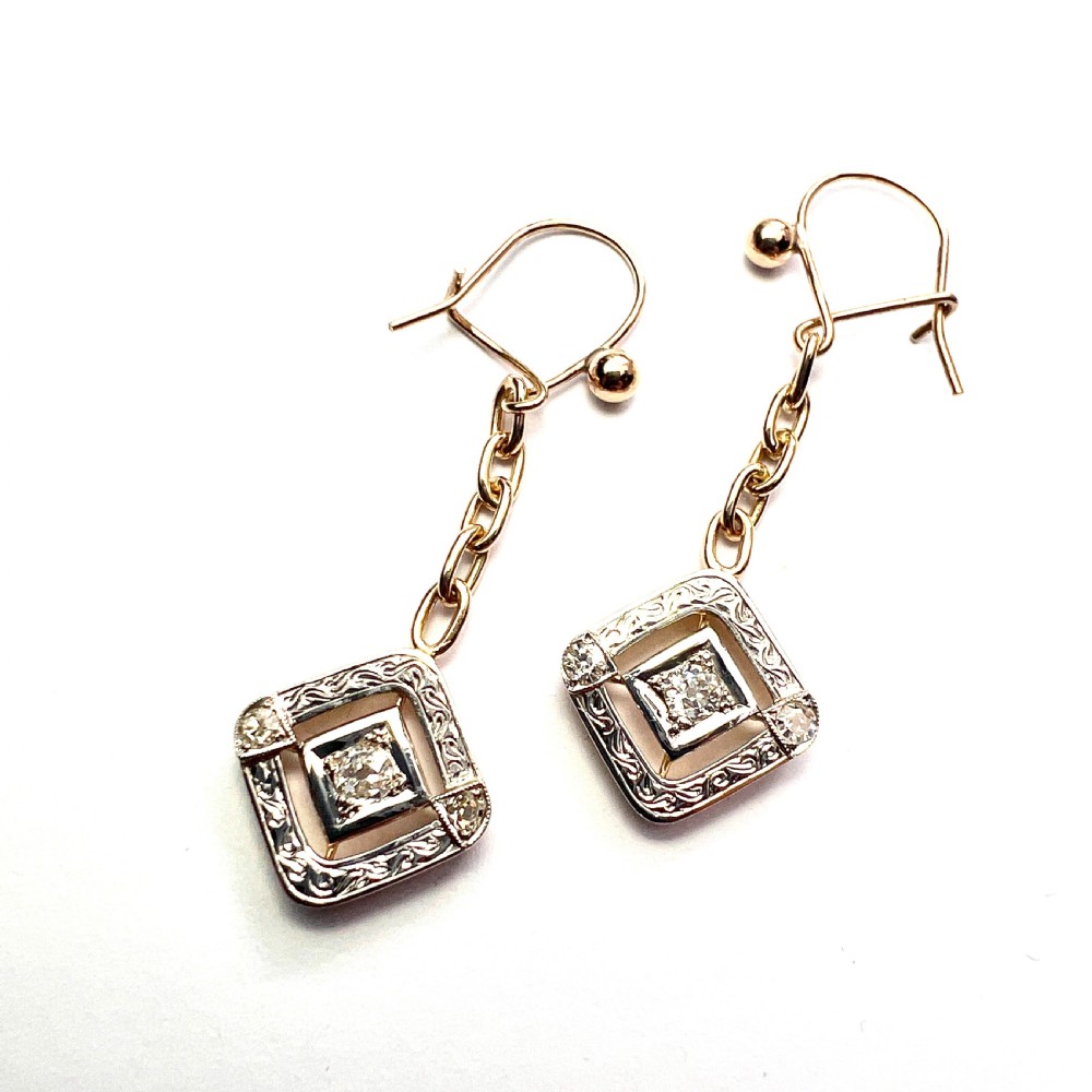 A pair of Edwardian style diamond drop earrings crafted in yellow and white gold with diamond-shaped engraved pendants. View III