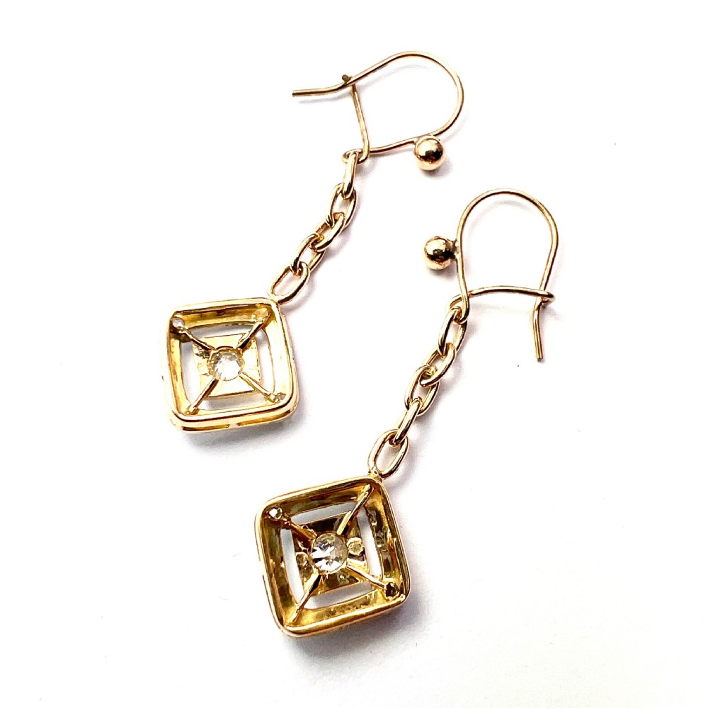 A pair of Edwardian style diamond drop earrings crafted in yellow and white gold with diamond-shaped engraved pendants. View VI