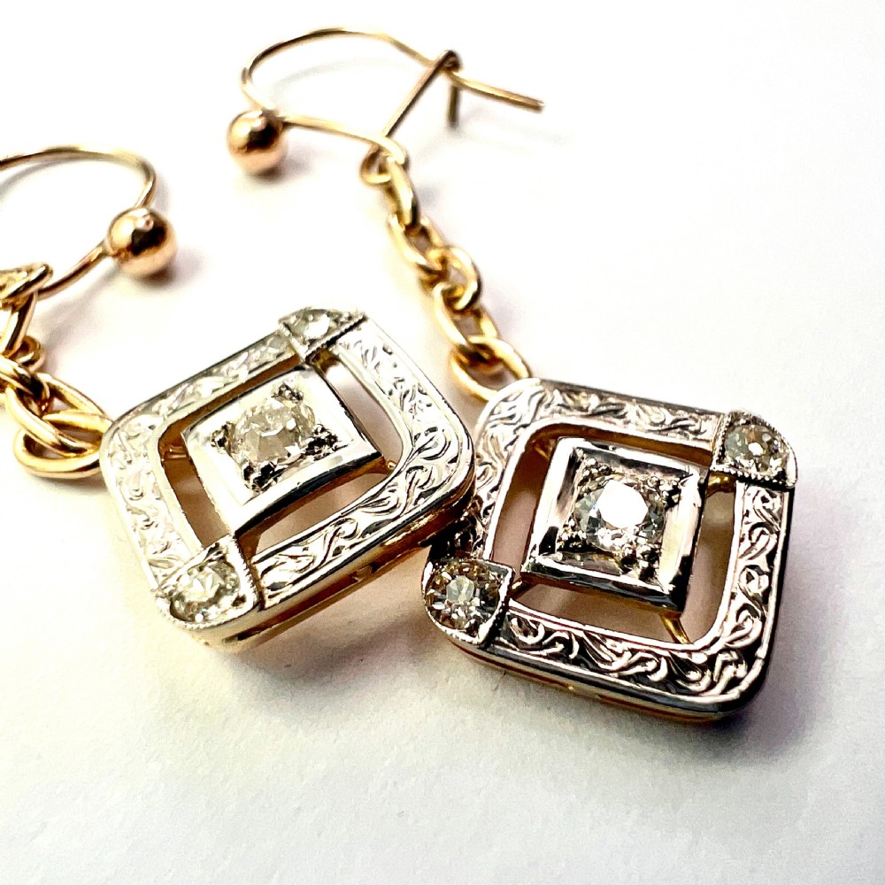 A pair of Edwardian style diamond drop earrings crafted in yellow and white gold with diamond-shaped engraved pendants. View VII