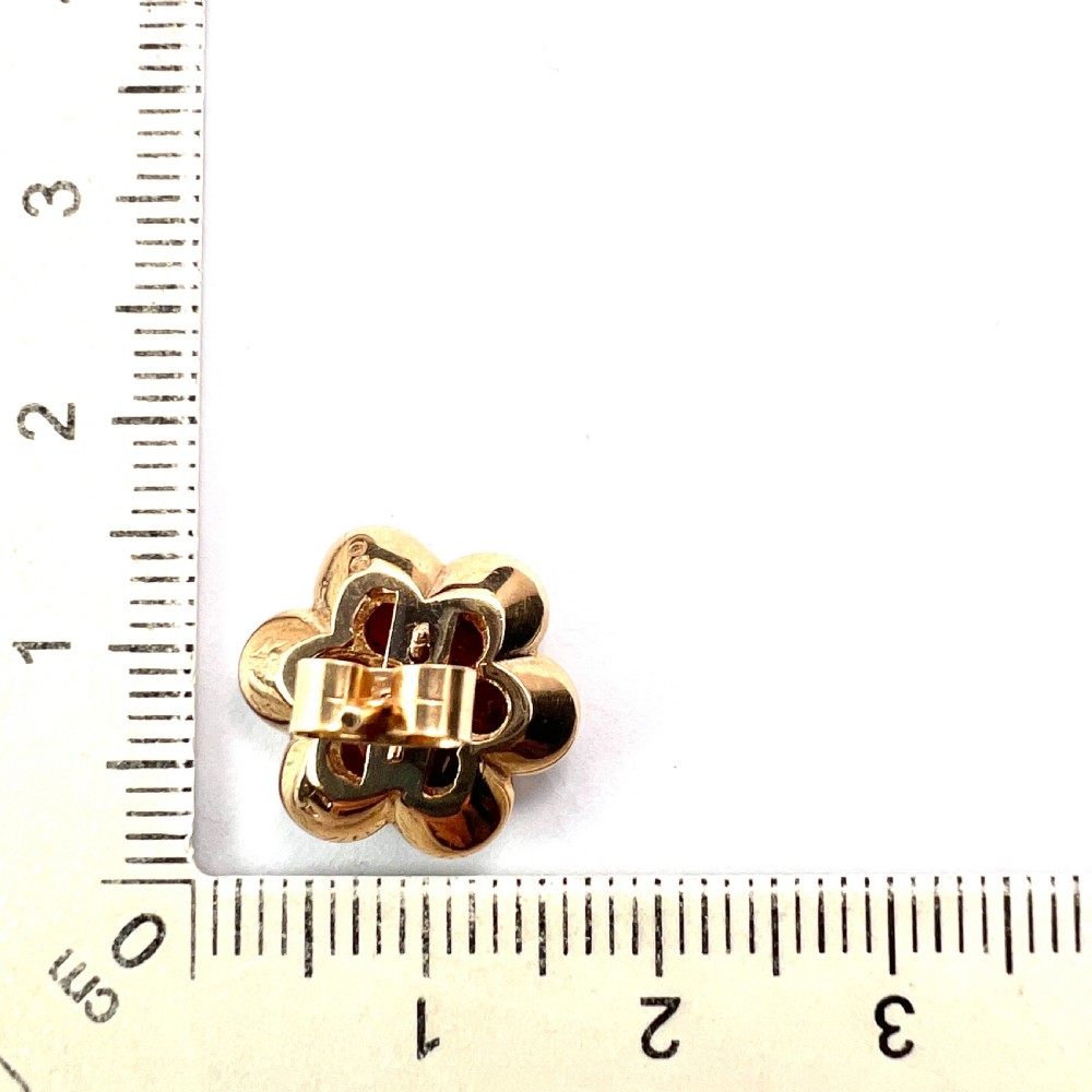 A pair of 9ct yellow gold floral cluster stud earrings set with round deep red garnet gemstones in claw settings. View VIII