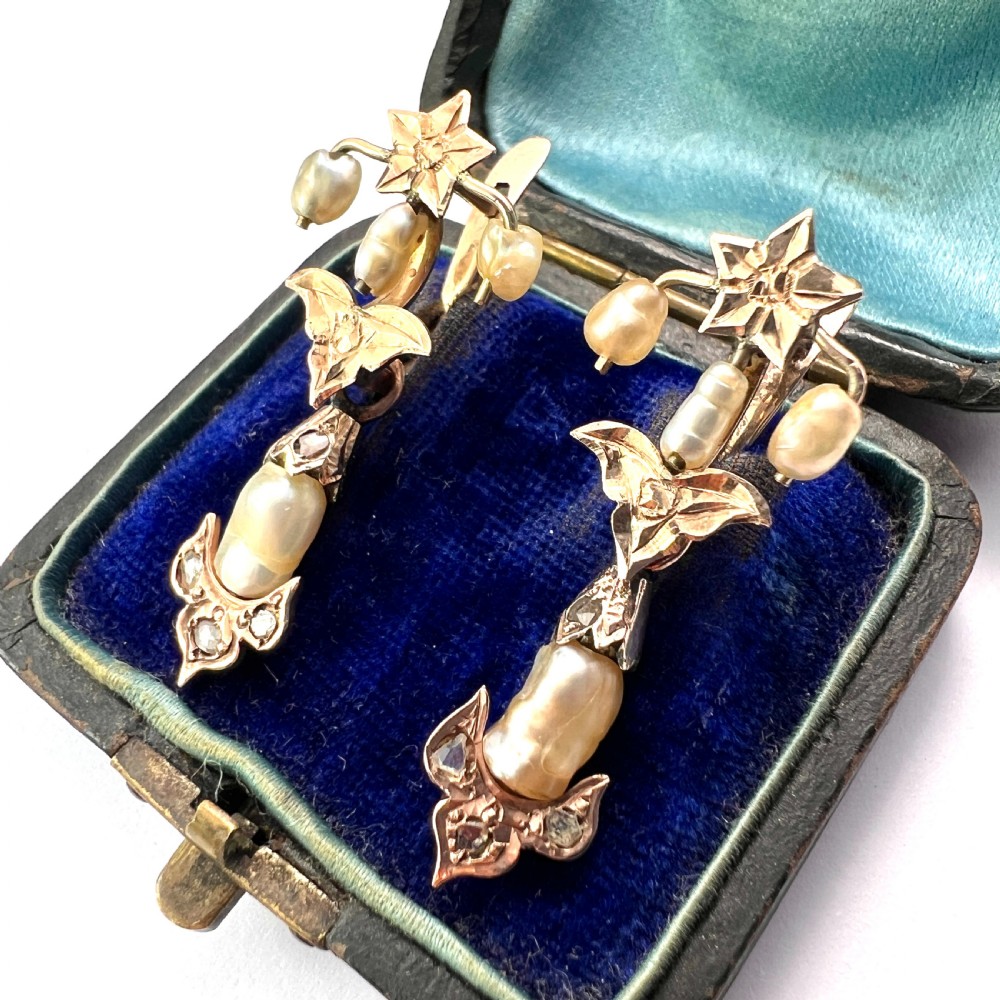 A pair of Art Nouveau gold drop earrings featuring star tops, leaf motifs set with small diamonds, and suspended baroque pearls. View II