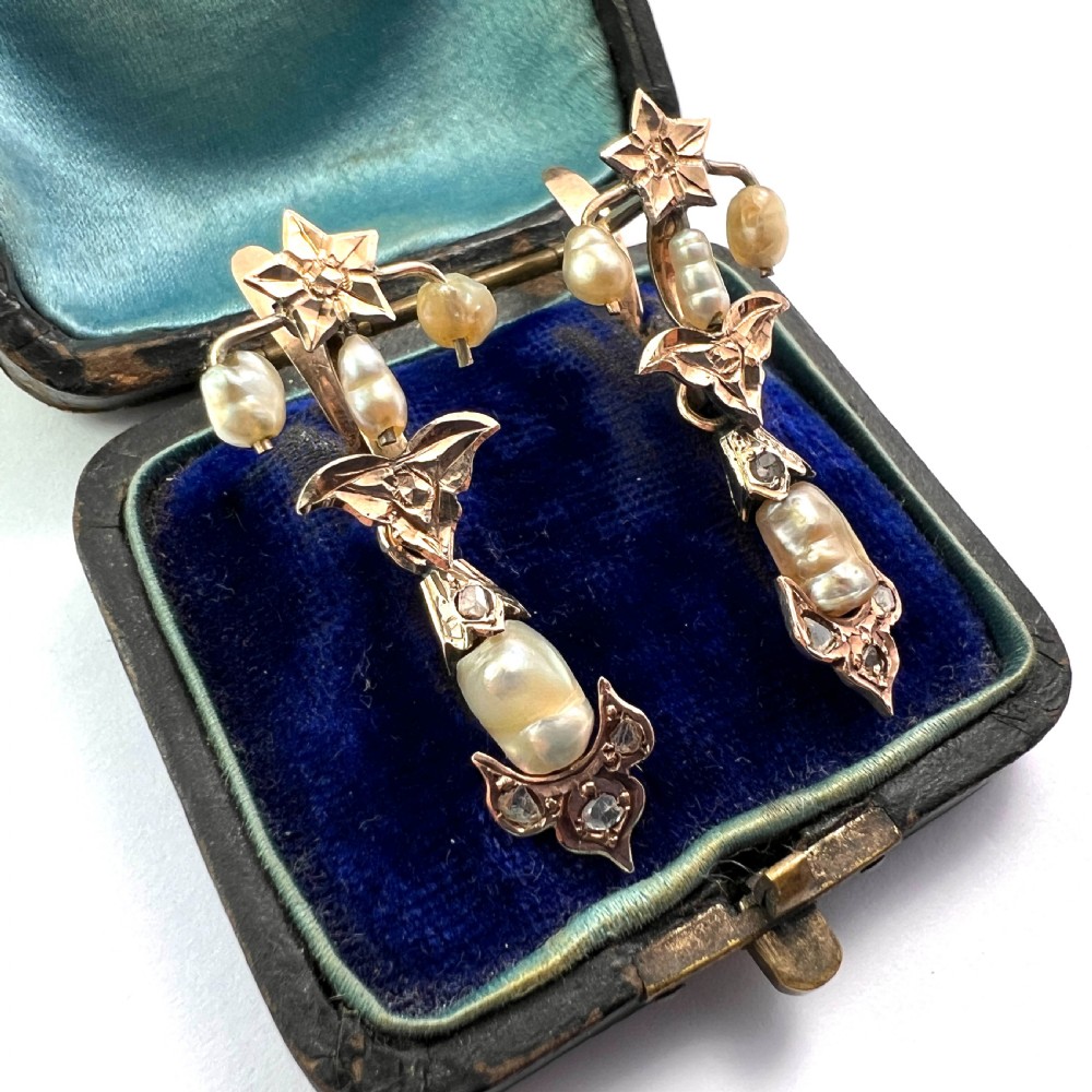 A pair of Art Nouveau gold drop earrings featuring star tops, leaf motifs set with small diamonds, and suspended baroque pearls. View III