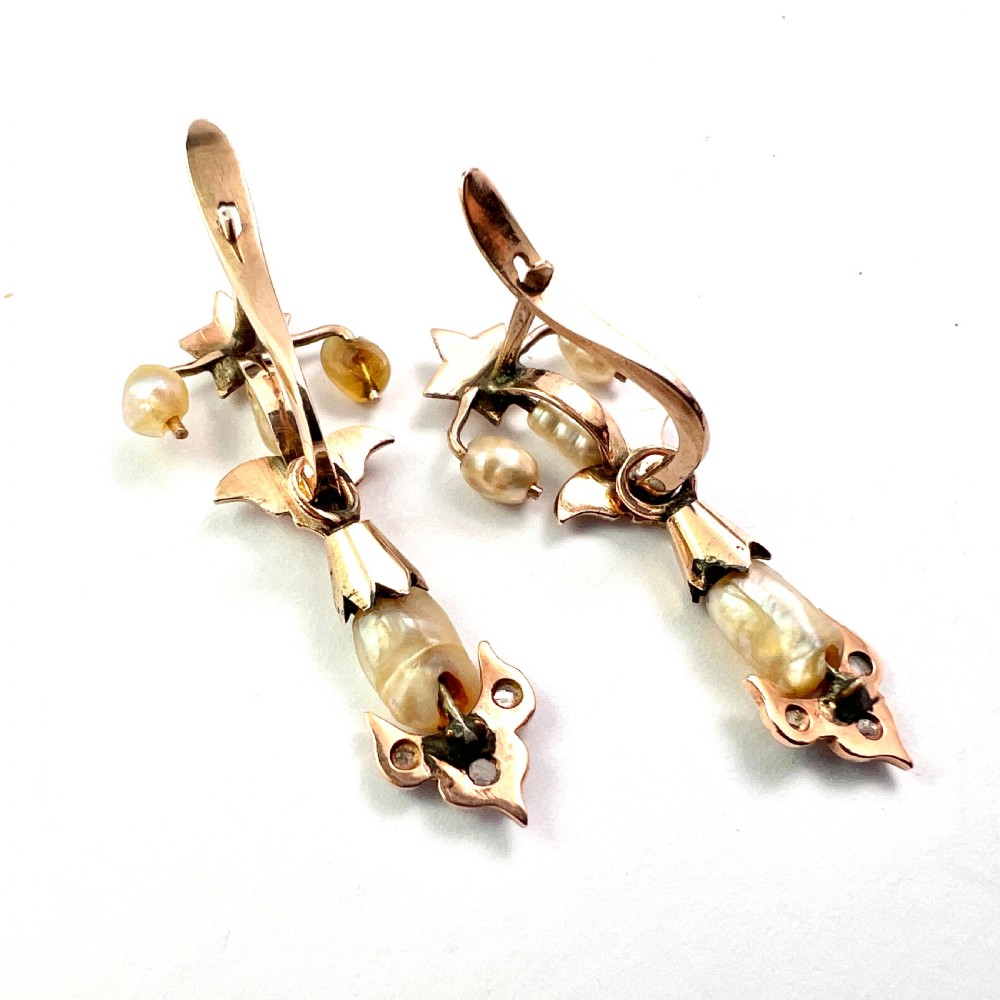 A pair of Art Nouveau gold drop earrings featuring star tops, leaf motifs set with small diamonds, and suspended baroque pearls. View VII