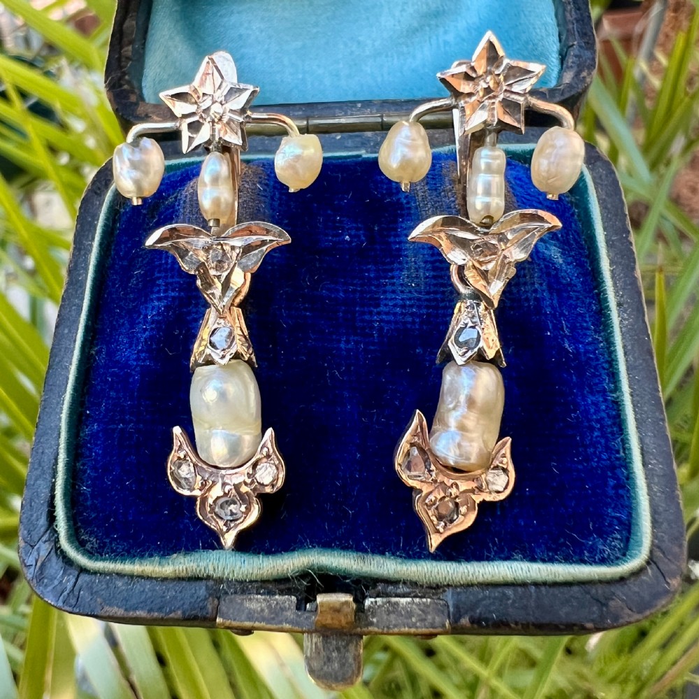 A pair of Art Nouveau gold drop earrings featuring star tops, leaf motifs set with small diamonds, and suspended baroque pearls. View IX