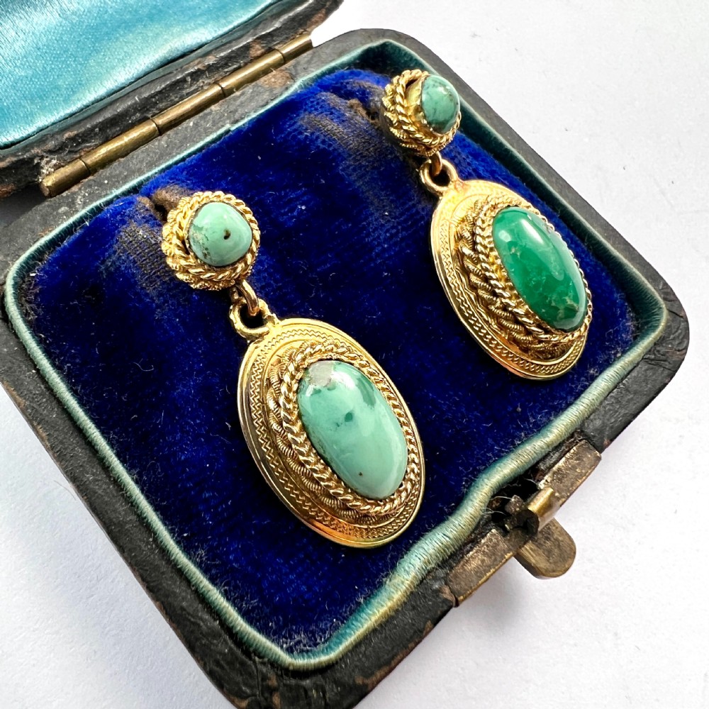 A pair of Etruscan Revival drop earrings in yellow gold featuring oval cabochon turquoise stones with detailed ropework and granulation. View III