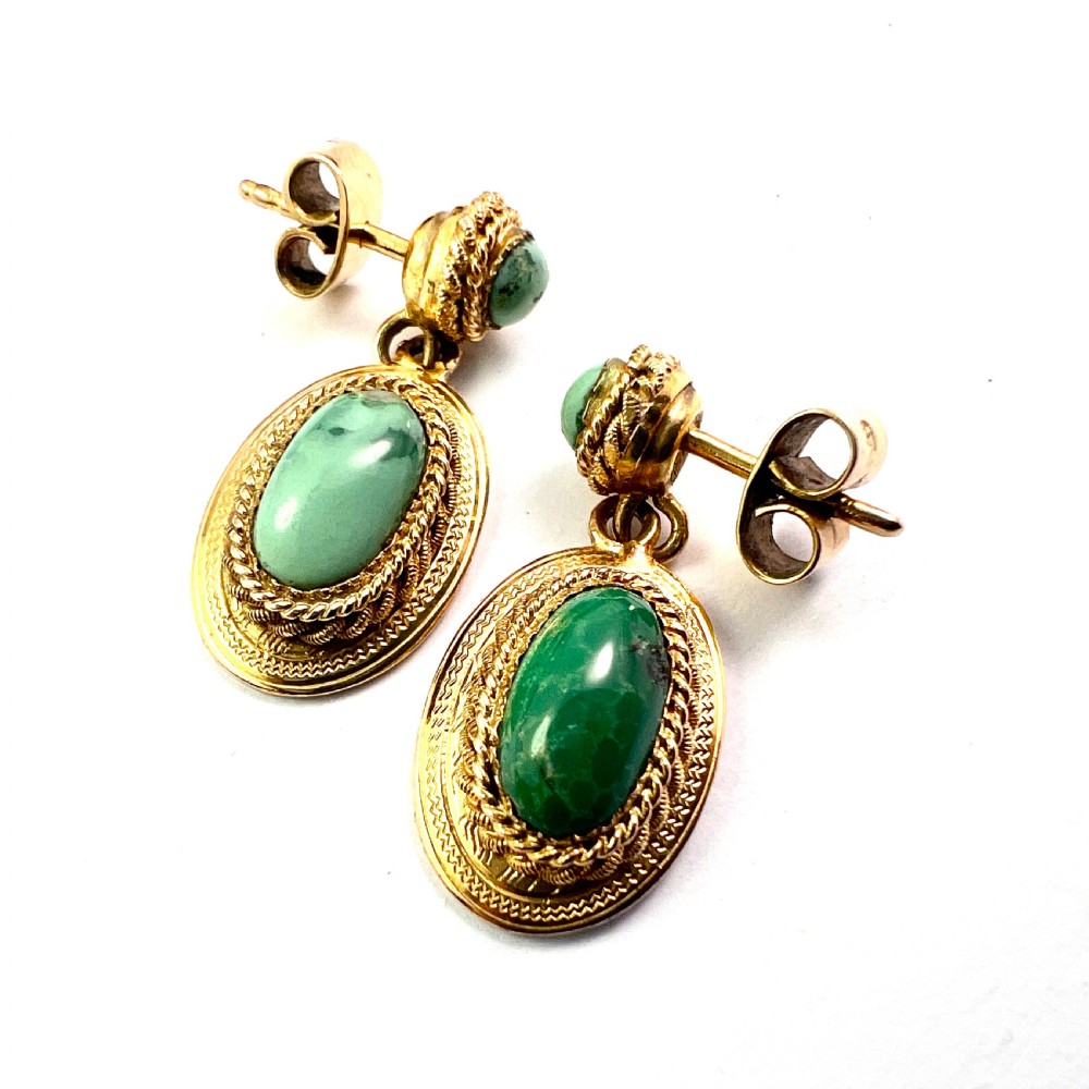 A pair of Etruscan Revival drop earrings in yellow gold featuring oval cabochon turquoise stones with detailed ropework and granulation. View IV