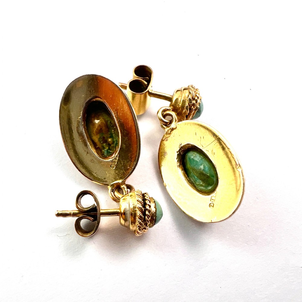 A pair of Etruscan Revival drop earrings in yellow gold featuring oval cabochon turquoise stones with detailed ropework and granulation. View V