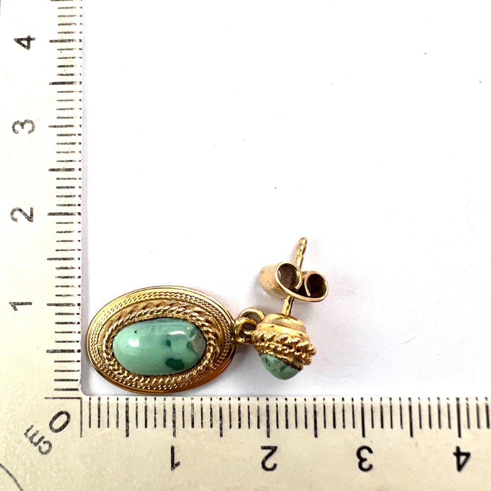 A pair of Etruscan Revival drop earrings in yellow gold featuring oval cabochon turquoise stones with detailed ropework and granulation. View VII