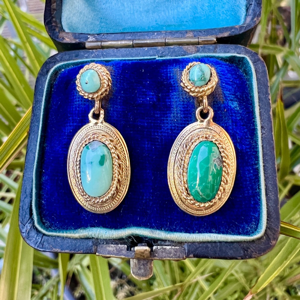 A pair of Etruscan Revival drop earrings in yellow gold featuring oval cabochon turquoise stones with detailed ropework and granulation. View VIII