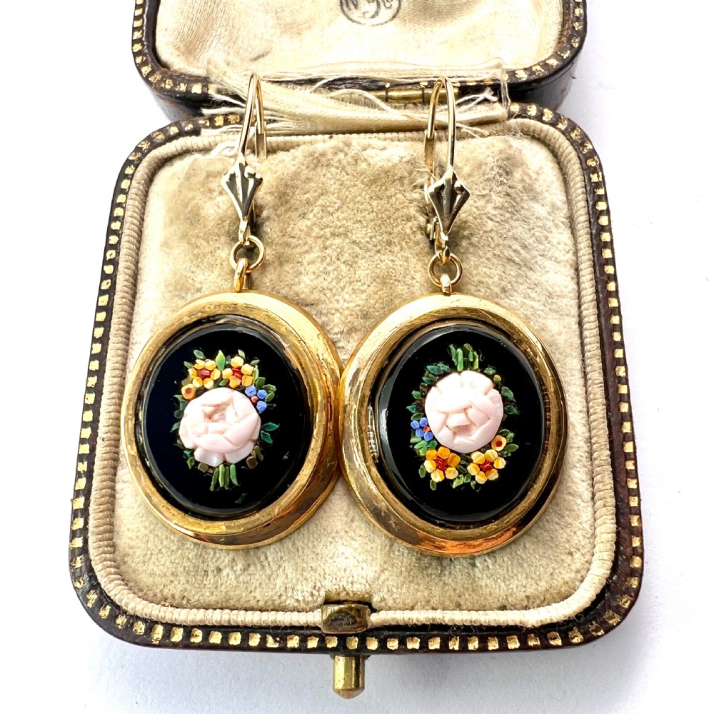 A pair of oval yellow gold drop earrings featuring micro mosaic floral designs with central pink roses on a black background.