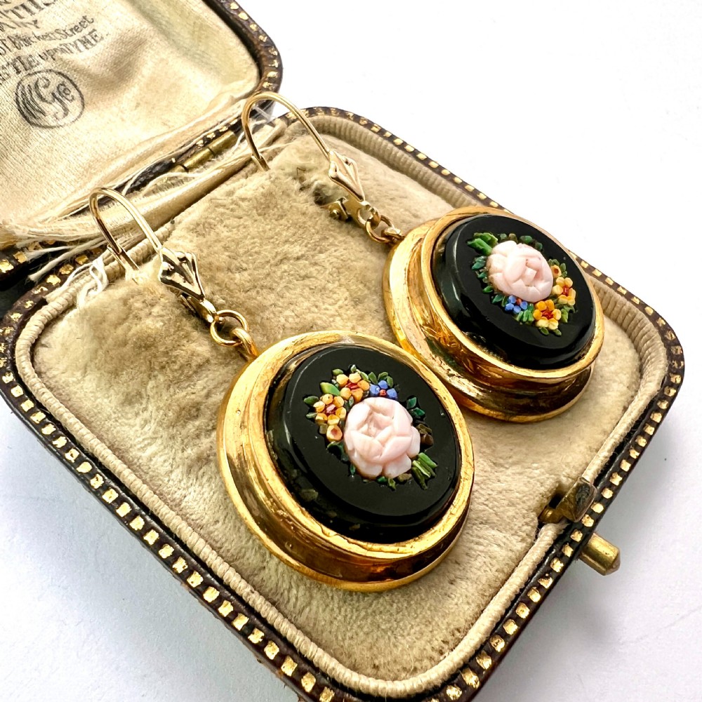 A pair of oval yellow gold drop earrings featuring micro mosaic floral designs with central pink roses on a black background. View III