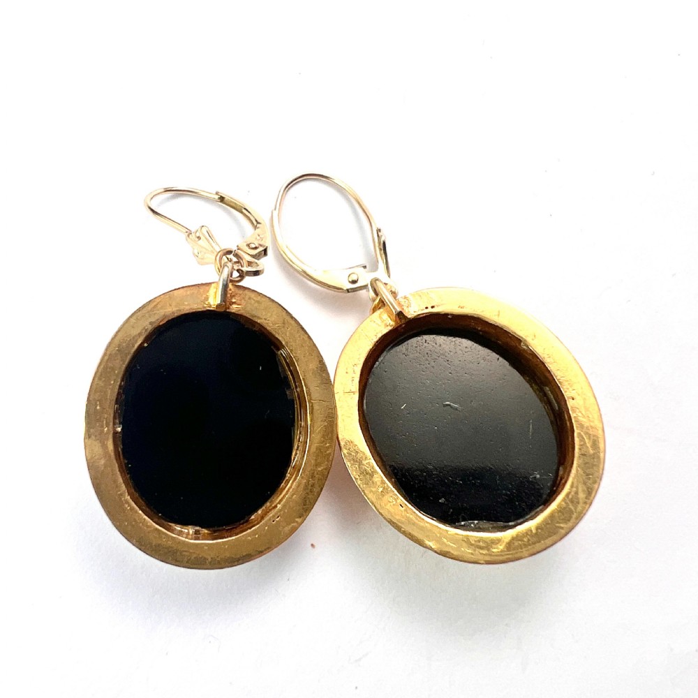 A pair of oval yellow gold drop earrings featuring micro mosaic floral designs with central pink roses on a black background. View V