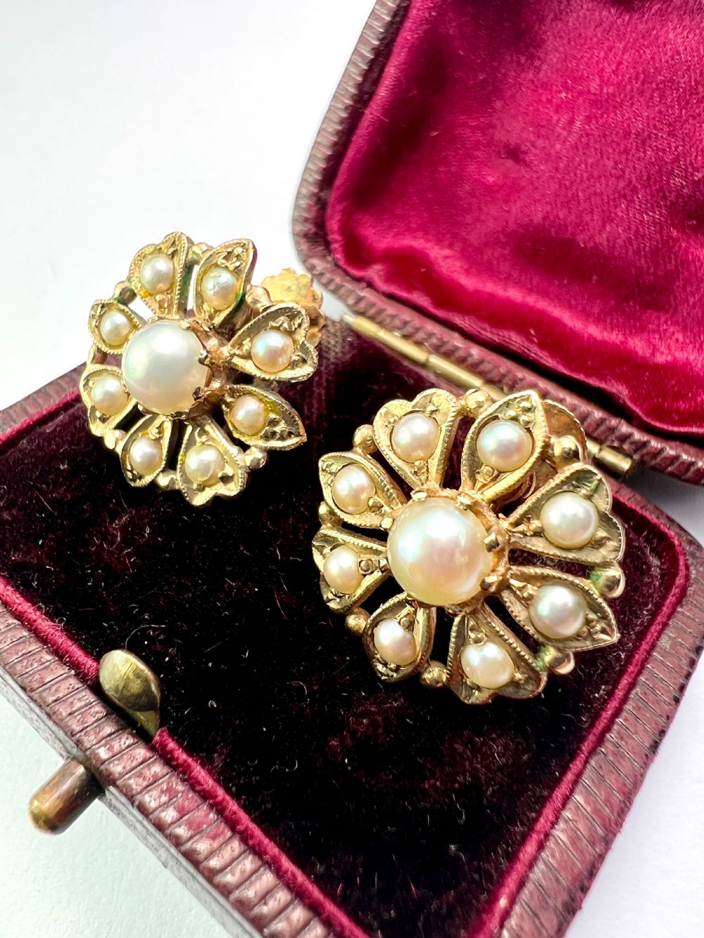 A pair of Victorian 9ct gold earrings featuring a central pearl surrounded by eight smaller seed pearls arranged in a floral cluster pattern. View II
