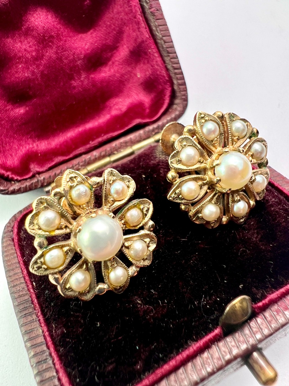 A pair of Victorian 9ct gold earrings featuring a central pearl surrounded by eight smaller seed pearls arranged in a floral cluster pattern. View III