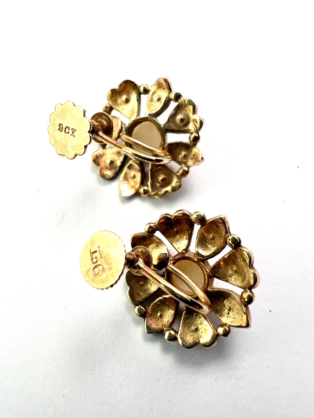 A pair of Victorian 9ct gold earrings featuring a central pearl surrounded by eight smaller seed pearls arranged in a floral cluster pattern. View V