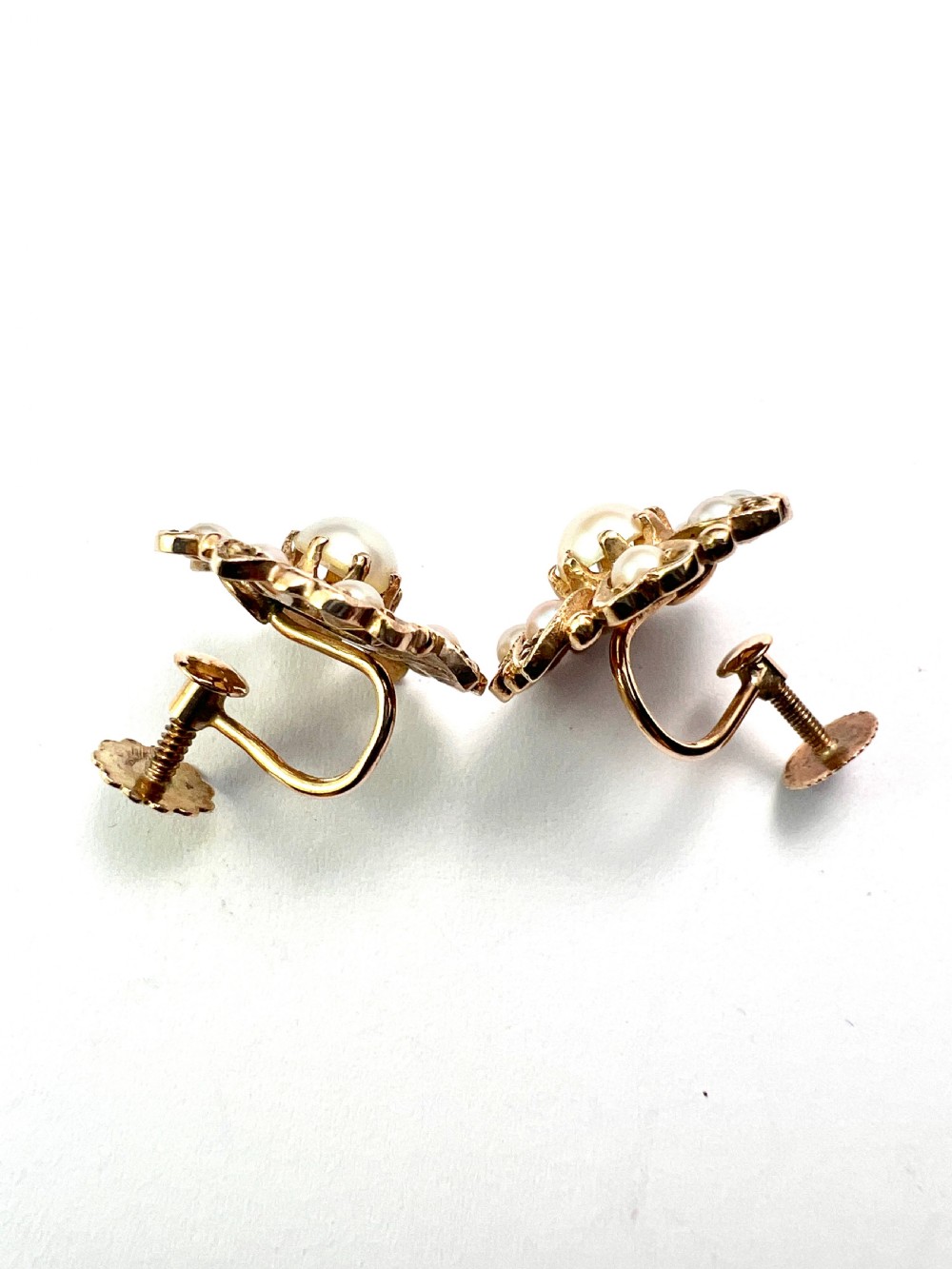 A pair of Victorian 9ct gold earrings featuring a central pearl surrounded by eight smaller seed pearls arranged in a floral cluster pattern. View VI