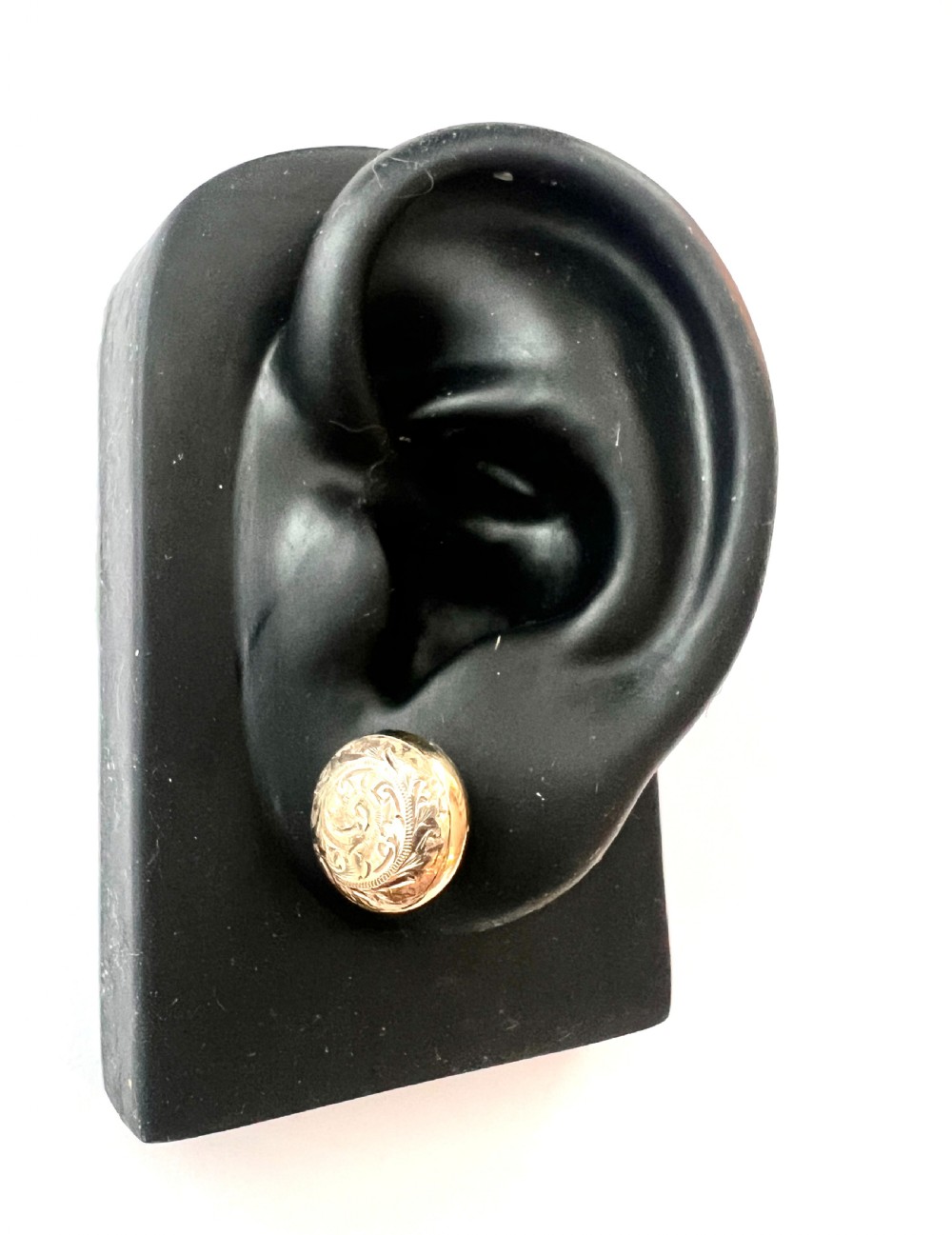 A pair of circular domed yellow gold stud earrings featuring hand-engraved scrollwork across the surface. View VI