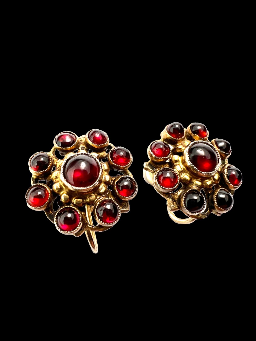 A pair of antique silver-gilt earrings set with deep red cabochon garnets arranged in a circular cluster halo design. View II
