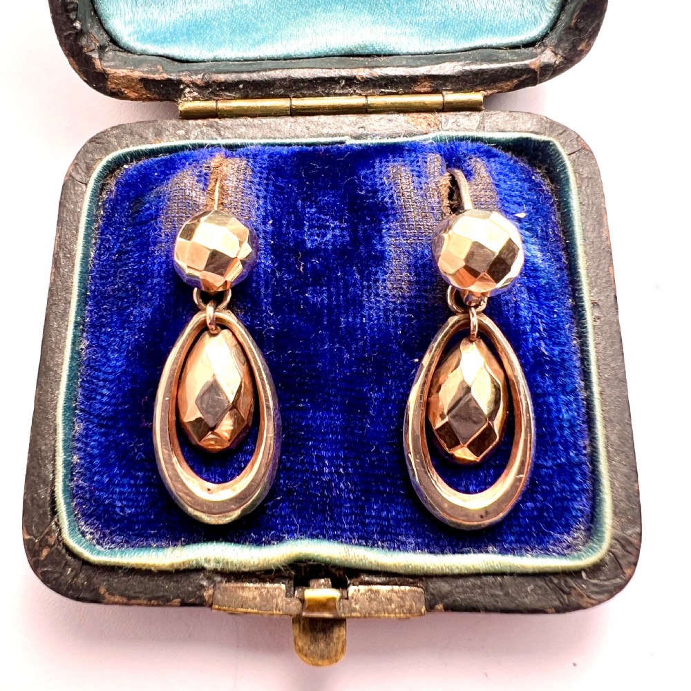 Pair of Victorian 9ct gold drop earrings featuring faceted top beads and suspended teardrops within oval hoops.