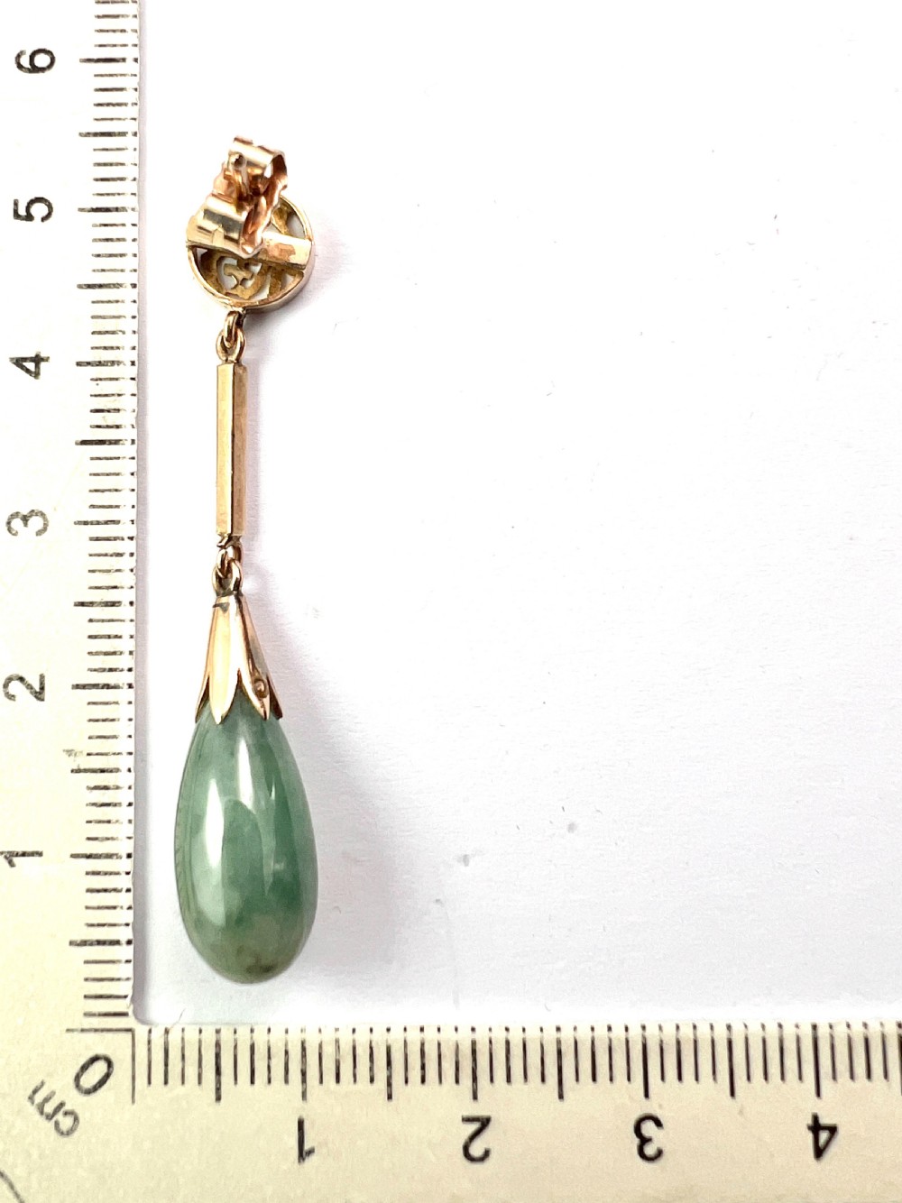 A pair of gold drop earrings featuring circular tops with pierced Chinese characters, slender gold bar links, and teardrop-shaped green jade stones. View VI