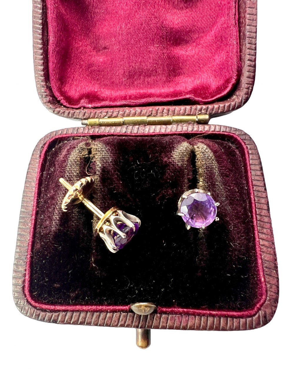 Pair of antique stud earrings featuring circular purple amethysts in multi-prong silver crown settings with yellow gold posts and scalloped backings. View V