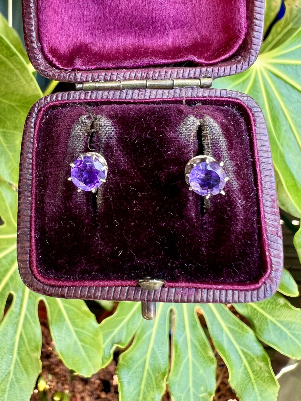 Pair of antique stud earrings featuring circular purple amethysts in multi-prong silver crown settings with yellow gold posts and scalloped backings. View VIII