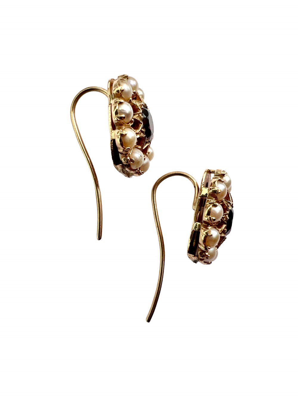 A pair of Victorian gold cluster earrings featuring a central round faceted red garnet surrounded by seed pearls set in a starburst pattern. View V