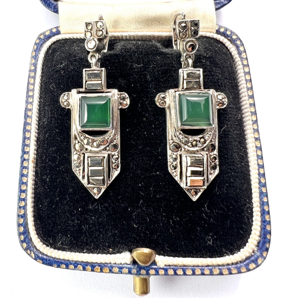 A pair of silver Art Deco drop earrings featuring square green chrysoprase cabochons within geometric stepped frames set with marcasite stones.