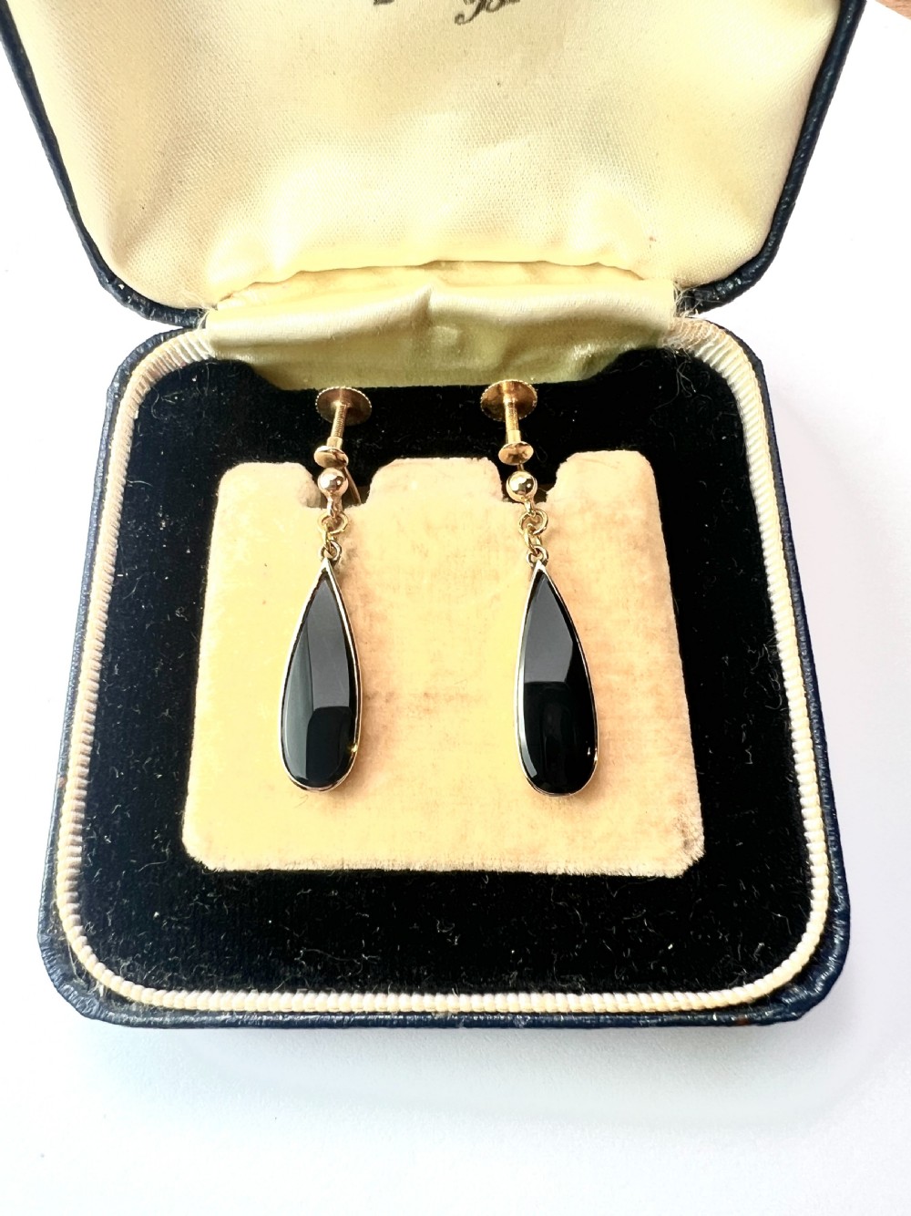 A pair of vintage 9ct yellow gold drop earrings featuring elongated black onyx teardrops suspended from screw-back fittings.