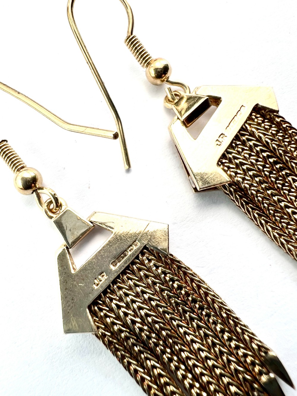 A pair of vintage 9ct gold drop earrings featuring textured geometric caps suspending multiple foxtail chain tassels with pointed tips. View V