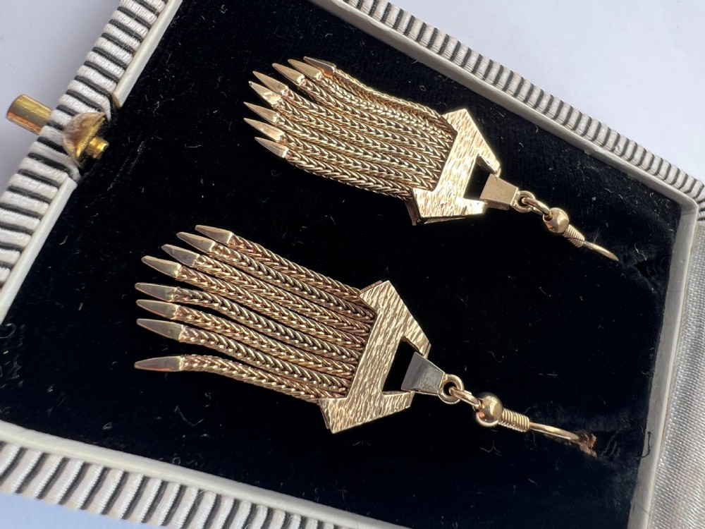 A pair of vintage 9ct gold drop earrings featuring textured geometric caps suspending multiple foxtail chain tassels with pointed tips. View VIII