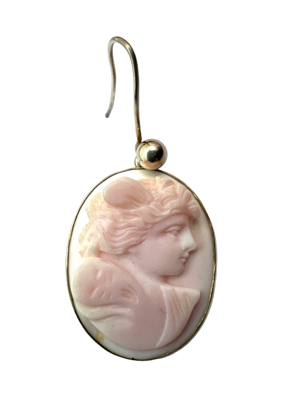 A pair of oval drop earrings featuring carved pink and white queen conch shell cameos depicting classical profile portraits set in silver mounts. View IV