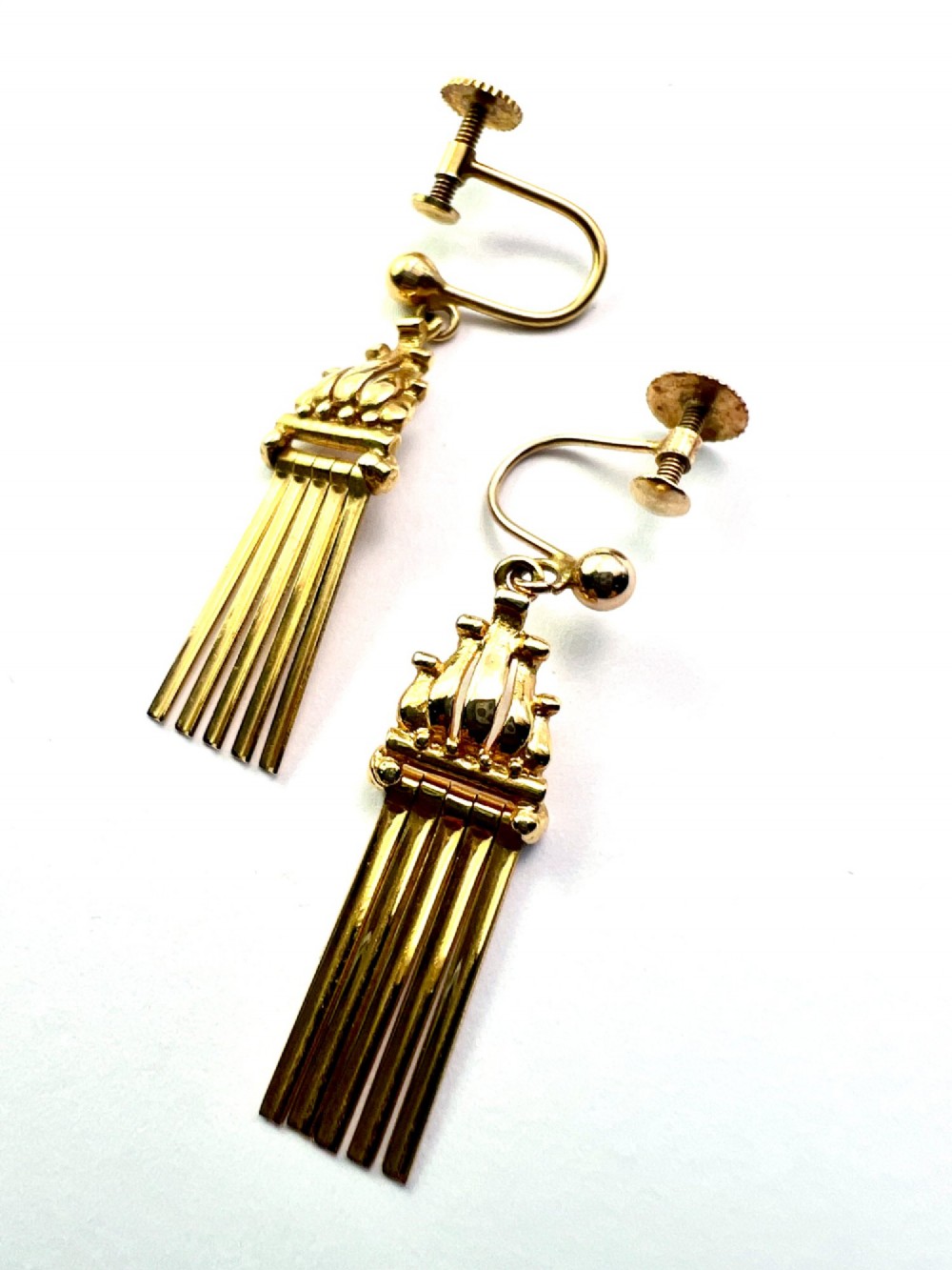 A pair of vintage 9ct yellow gold drop earrings featuring articulated fringe tassels suspended from decorative caps with screw-back fastenings. View IV