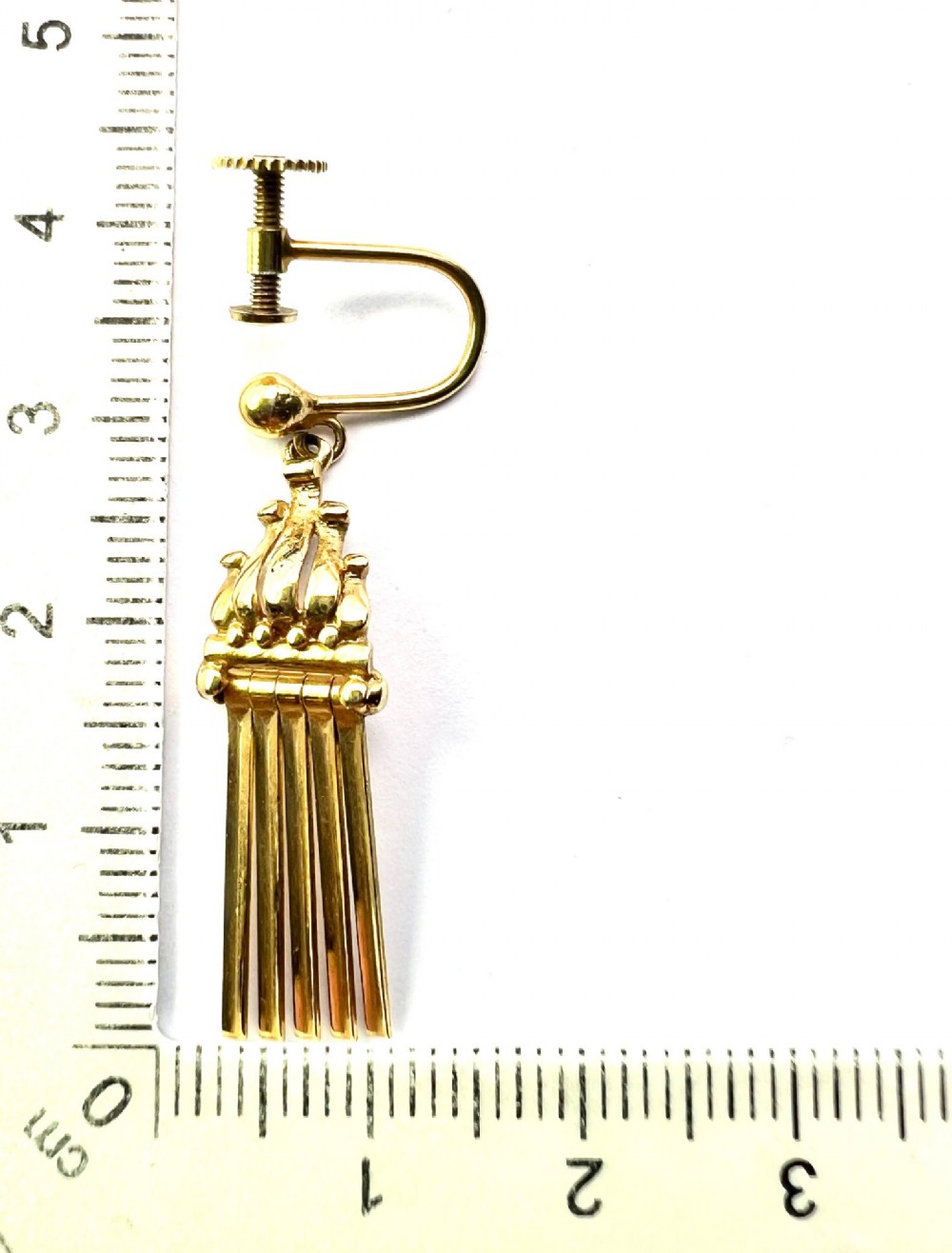 A pair of vintage 9ct yellow gold drop earrings featuring articulated fringe tassels suspended from decorative caps with screw-back fastenings. View VI