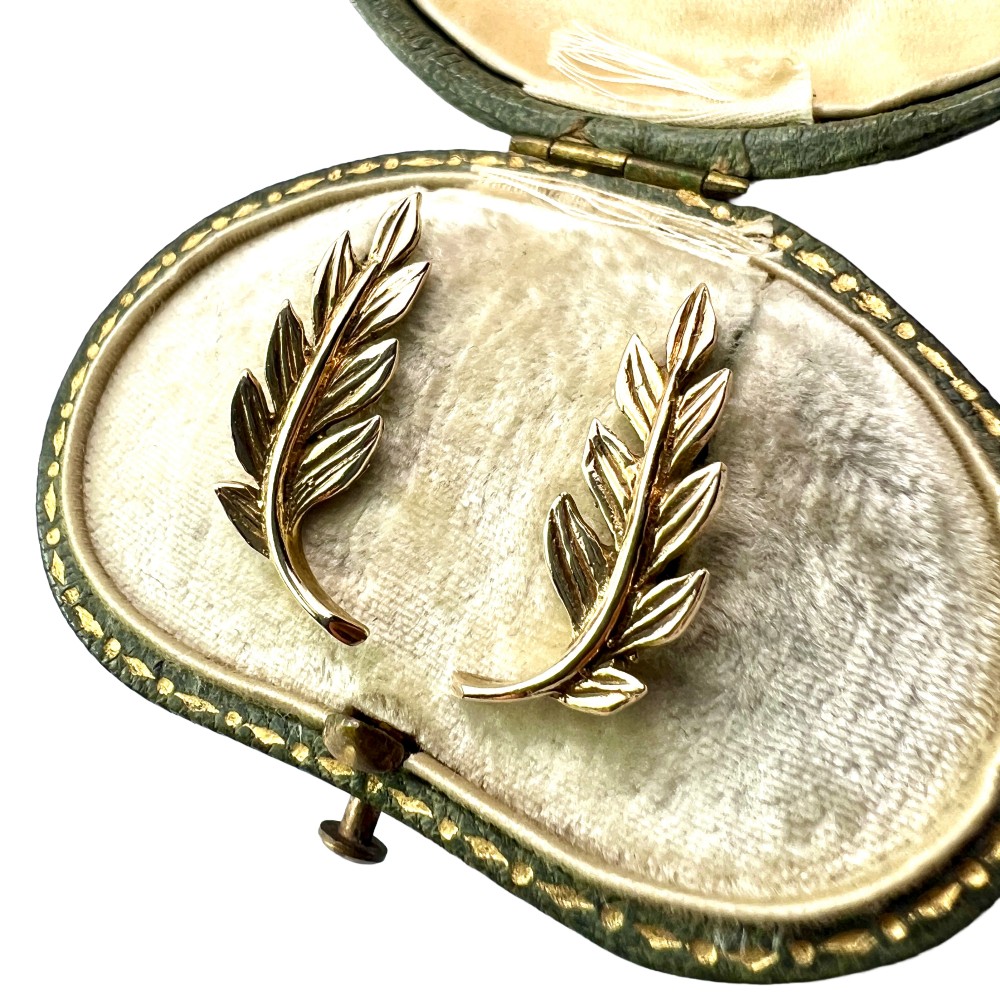 A pair of 9ct yellow gold stud earrings crafted in the shape of curved laurel leaf branches with textured vein details.