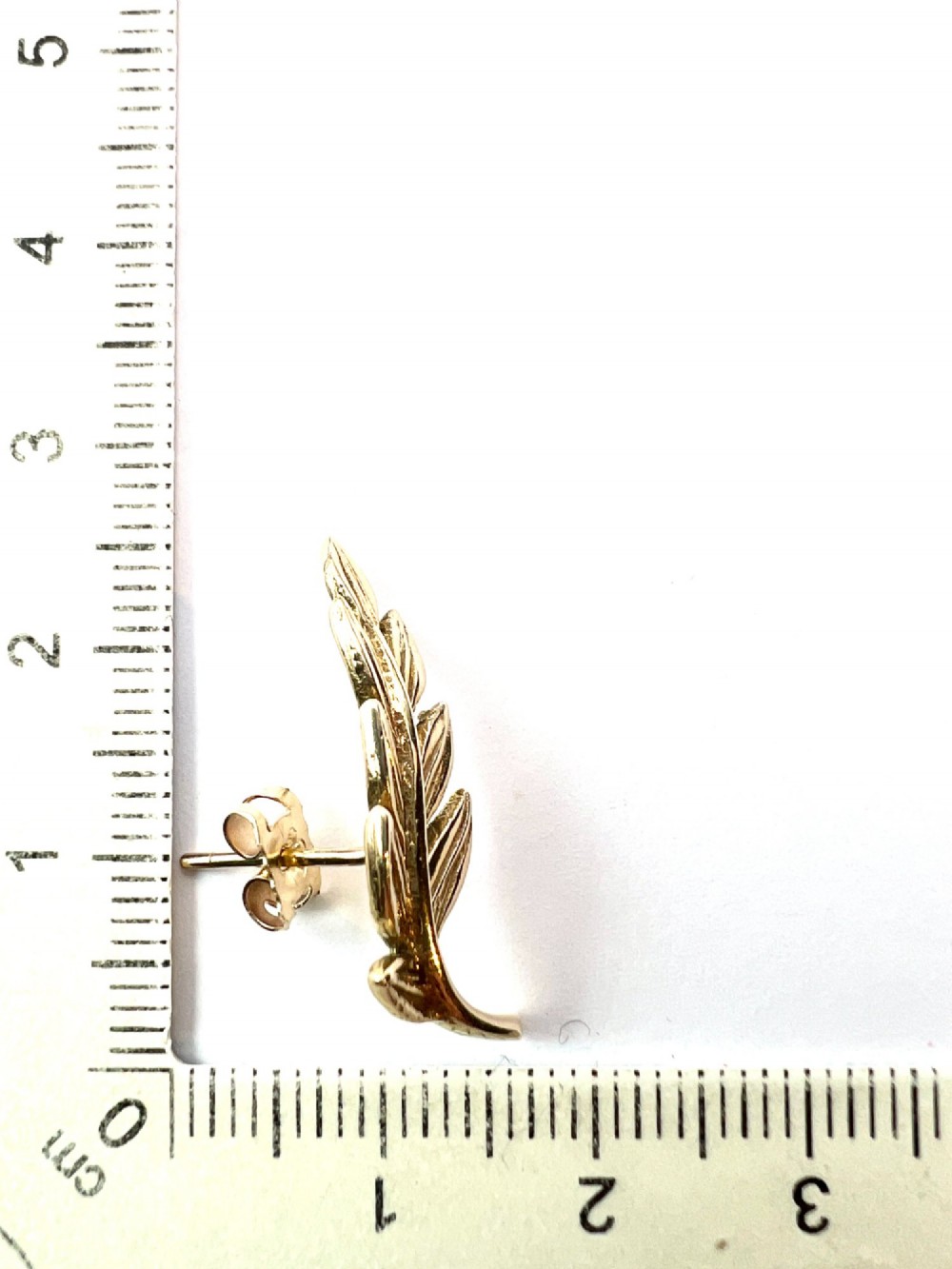 A pair of 9ct yellow gold stud earrings crafted in the shape of curved laurel leaf branches with textured vein details. View VII
