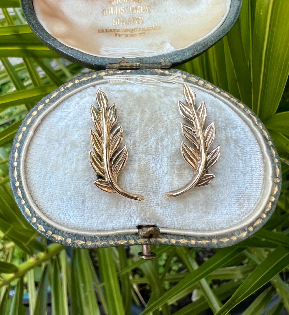 A pair of 9ct yellow gold stud earrings crafted in the shape of curved laurel leaf branches with textured vein details. View VIII