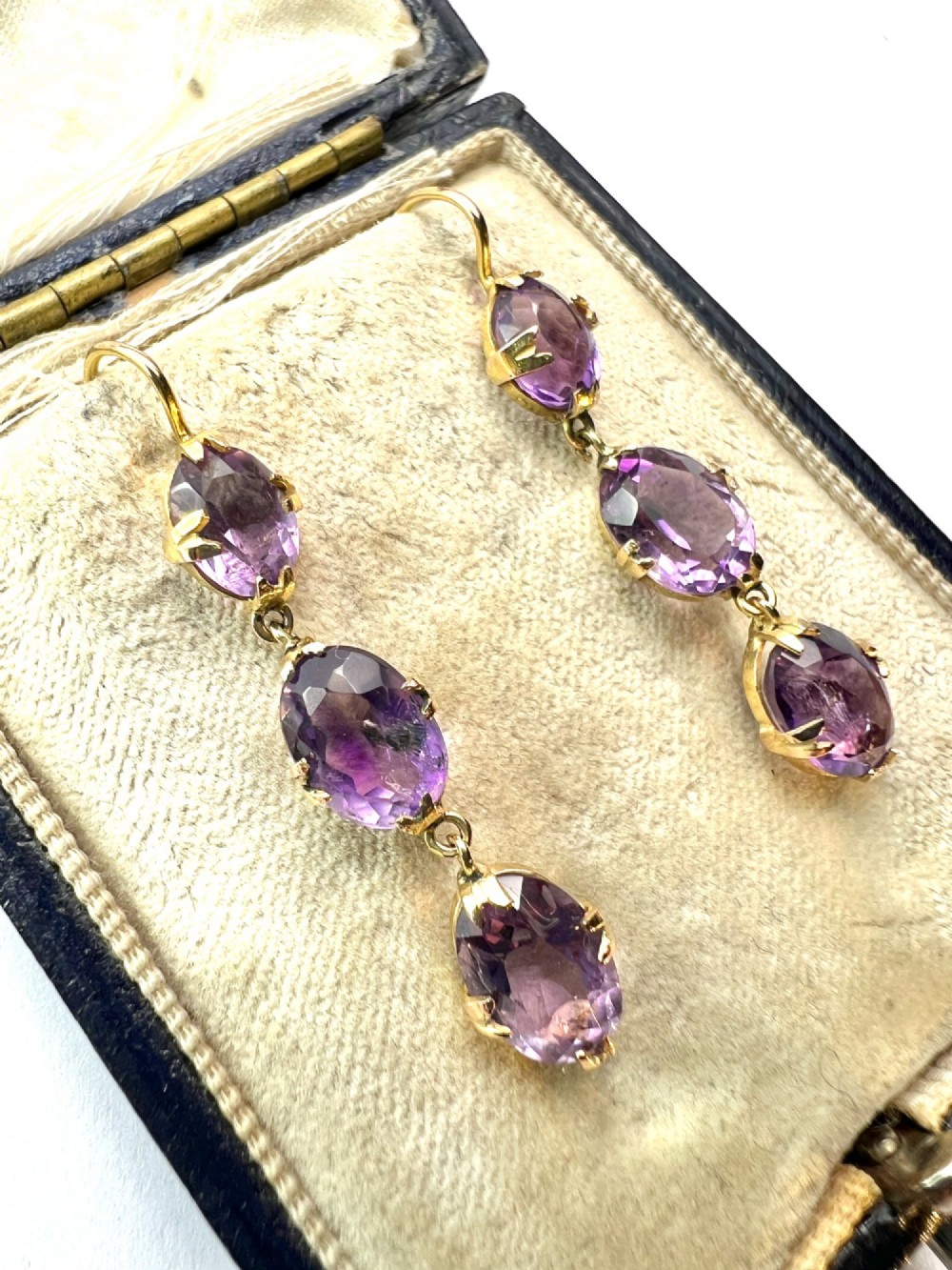 A pair of antique 9ct yellow gold drop earrings, each set with three articulated oval faceted purple amethysts in claw mounts. View II
