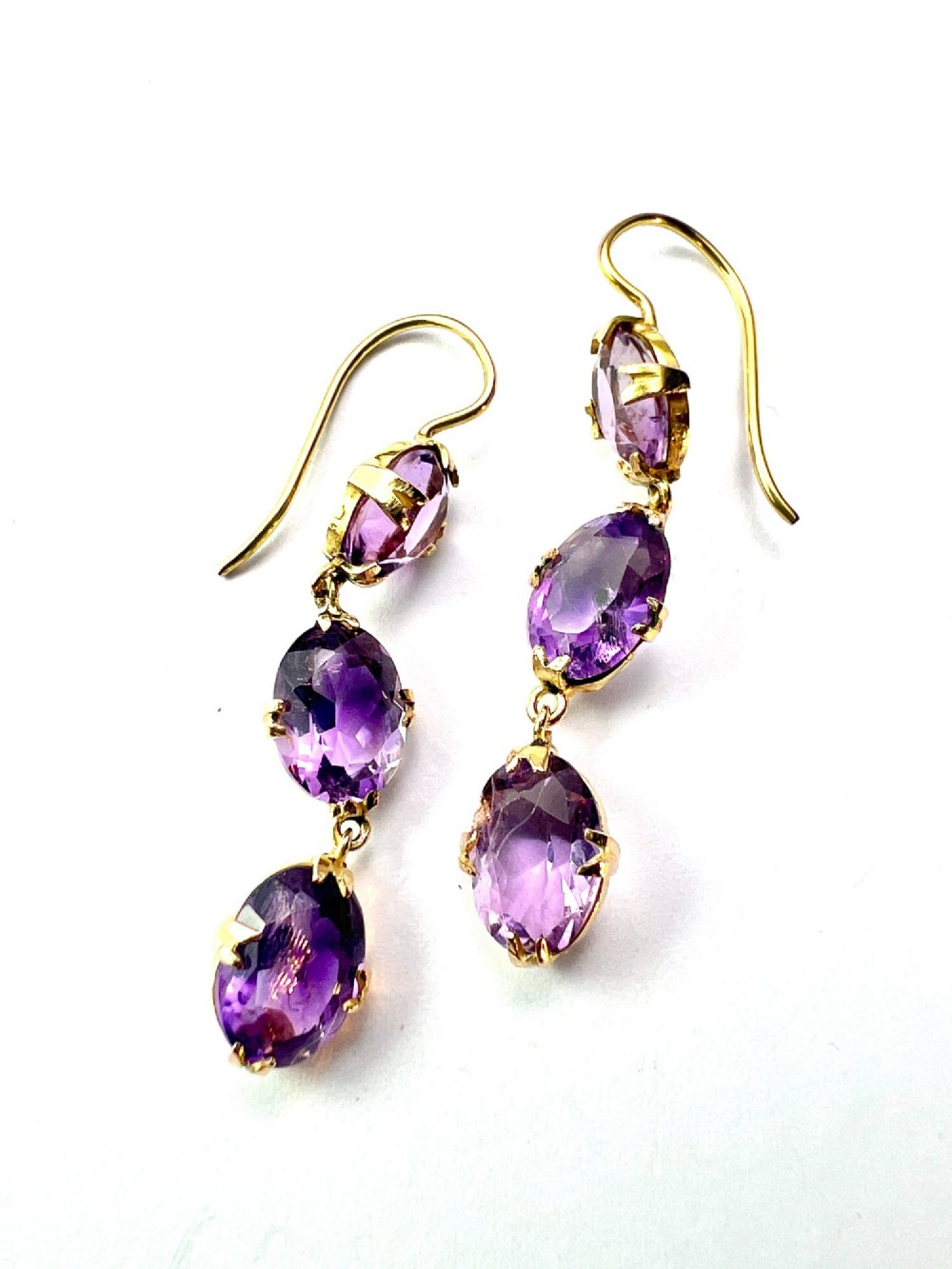 A pair of antique 9ct yellow gold drop earrings, each set with three articulated oval faceted purple amethysts in claw mounts. View III