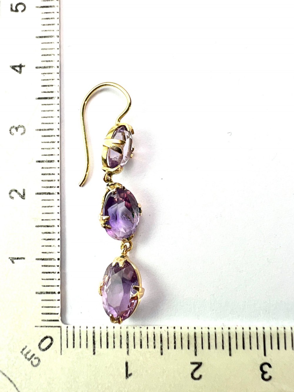 A pair of antique 9ct yellow gold drop earrings, each set with three articulated oval faceted purple amethysts in claw mounts. View VI