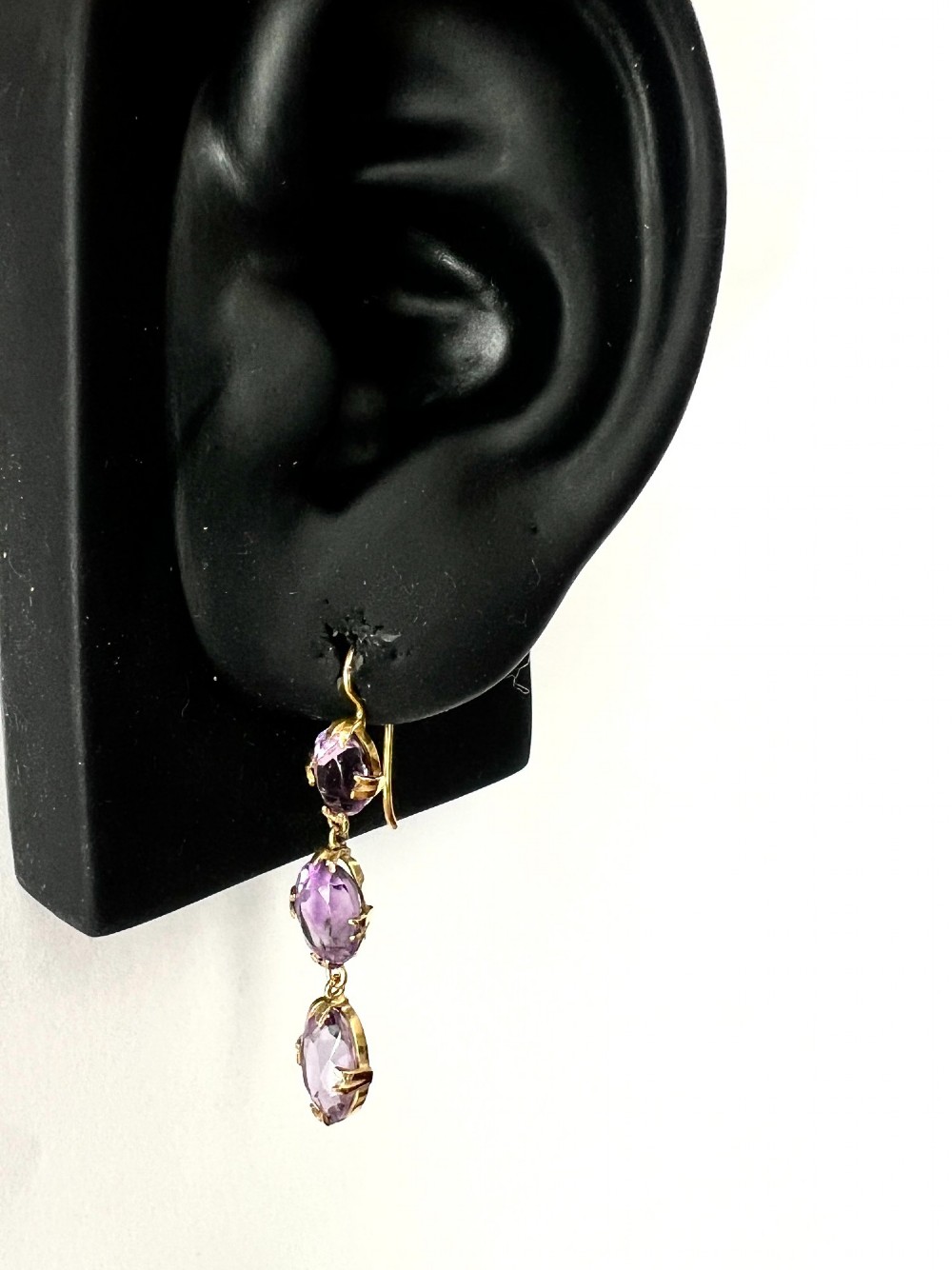 A pair of antique 9ct yellow gold drop earrings, each set with three articulated oval faceted purple amethysts in claw mounts. View VII