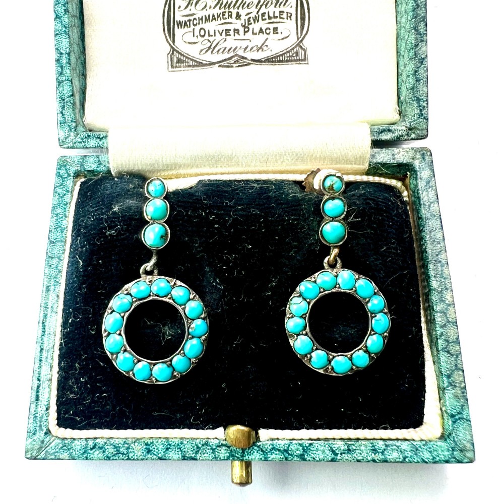 A pair of Victorian gold and silver drop earrings featuring circular open-hoop motifs set with small turquoise cabochons.