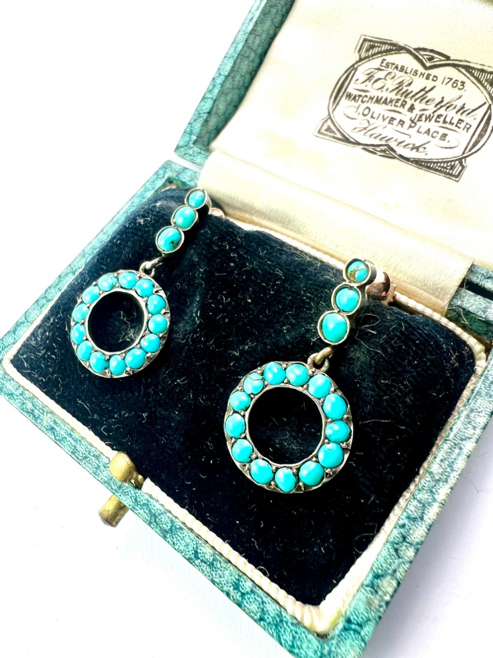A pair of Victorian gold and silver drop earrings featuring circular open-hoop motifs set with small turquoise cabochons. View II