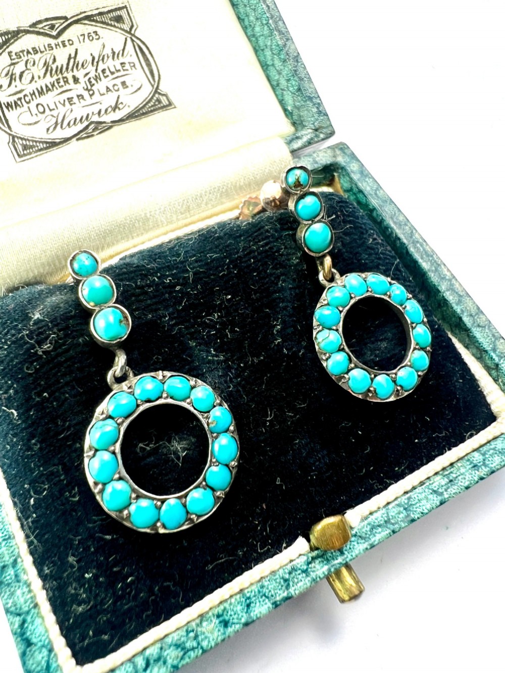 A pair of Victorian gold and silver drop earrings featuring circular open-hoop motifs set with small turquoise cabochons. View III